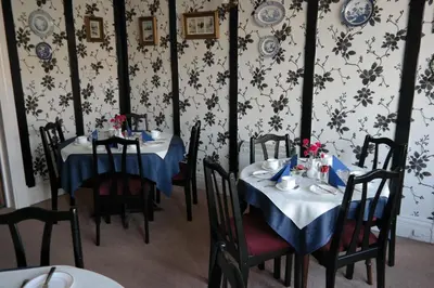 a dining room with two tables with blue and white tablecloths at OLIVERS Strickley over 35 years only in Blackpool