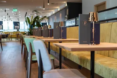 a row of tables and chairs in a restaurant at Holiday Inn Blackpool by IHG in Blackpool