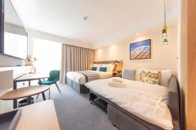 a hotel room with two beds and a desk at Holiday Inn Blackpool by IHG in Blackpool