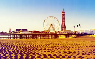 a view of a beach with a ferris wheel in the background at Holiday Inn Blackpool by IHG in Blackpool