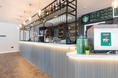 a bar in a restaurant with a counter with drinks at Holiday Inn Blackpool by IHG in Blackpool
