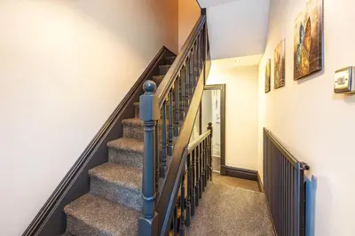 a staircase in a home with a blue hand rail at Spacious & Stylish 5 Bed with Free Street Parking in Morecambe