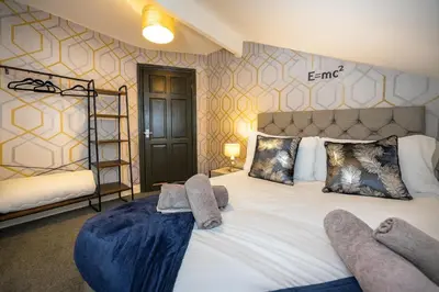 a bedroom with a large bed with two pairs of socks on it at Spacious & Stylish 5 Bed with Free Street Parking in Morecambe