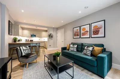 a living room with a blue couch and a kitchen at Host & Stay - Henry Street Chambers in Liverpool