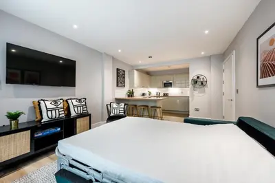 a bedroom with a large bed and a kitchen at Host & Stay - Henry Street Chambers in Liverpool
