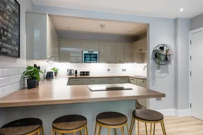 a kitchen with a wooden counter and stools at Host & Stay - Henry Street Chambers in Liverpool