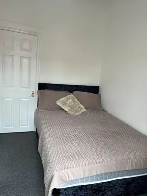 a bedroom with a bed with a pillow on it at The First-central Wigan 8 guests in Wigan