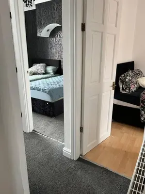 a room with a bedroom with a bed and a mirror at The First-central Wigan 8 guests in Wigan