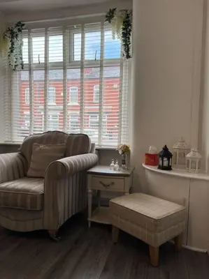 a living room with a chair and a table at The First-central Wigan 8 guests in Wigan