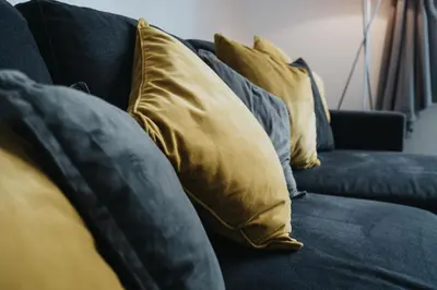 a blue couch with yellow pillows on it at Kinetic Stays - Symphony Building in Liverpool