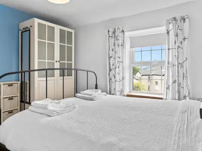a white bedroom with a bed and a window at Quaint Cottage Retreat in Charming Ulverston - Pass the Keys in Ulverston