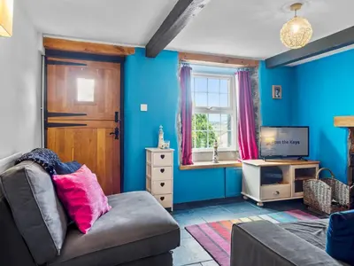 a living room with a couch and a tv at Quaint Cottage Retreat in Charming Ulverston - Pass the Keys in Ulverston