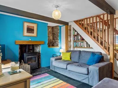 a living room with a couch and a staircase at Quaint Cottage Retreat in Charming Ulverston - Pass the Keys in Ulverston