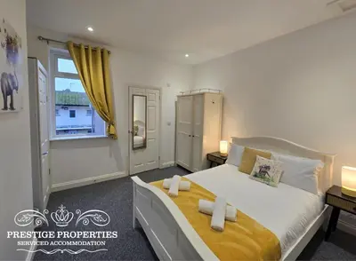 a bedroom with a large bed and a window at 52 Wordsworth Street by Prestige Properties SA in Barrow in Furness
