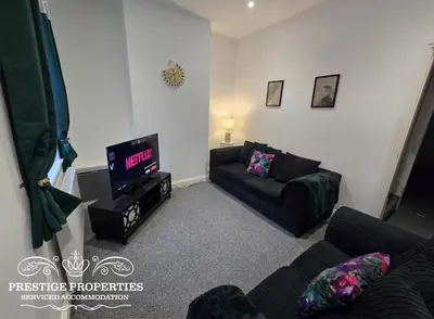 a living room with a couch and a tv at 52 Wordsworth Street by Prestige Properties SA in Barrow in Furness