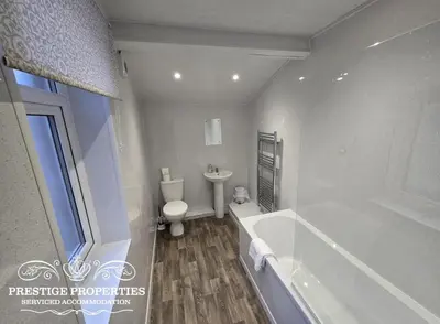 a bathroom with a tub and a toilet and a sink at 52 Wordsworth Street by Prestige Properties SA in Barrow in Furness