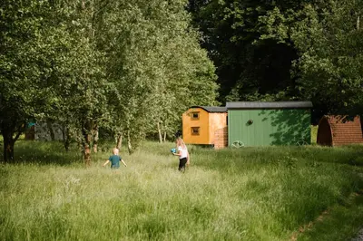 two children playing with a frisbee in a field at The Hamlet at Samlesbury Hall in Balderstone