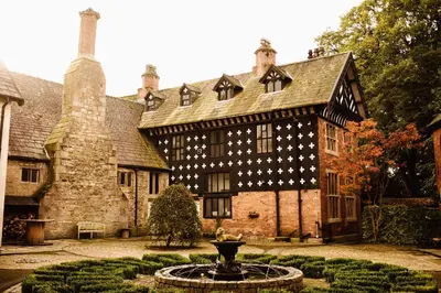 an old house with a fountain in front of it at The Hamlet at Samlesbury Hall in Balderstone