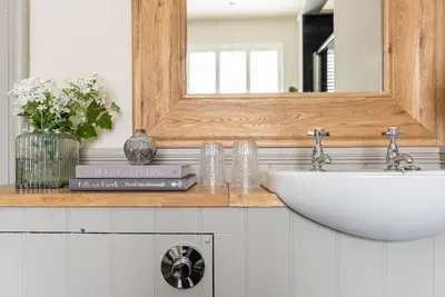 a bathroom with a sink and a mirror and books at The Gatehouse at Samlesbury Hall in Samlesbury