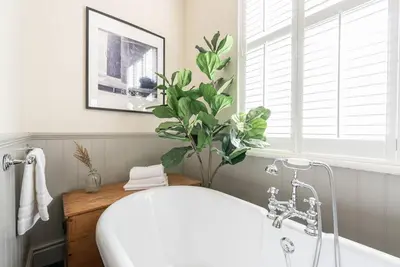 a bathroom with a white tub and a plant at The Gatehouse at Samlesbury Hall in Samlesbury