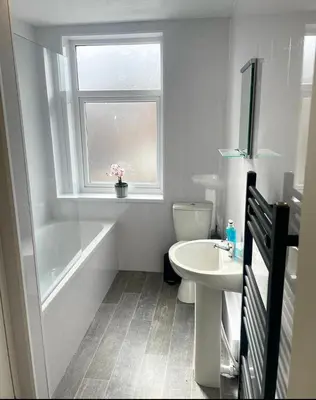 a bathroom with a sink and a window and a toilet at 38 Gloucester street by Prestige Properties SA in Barrow in Furness