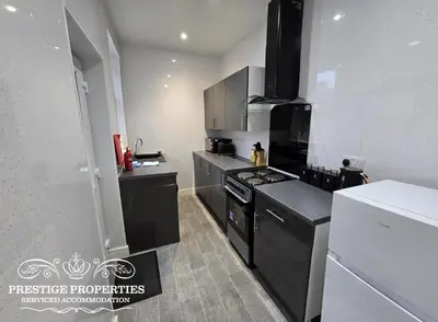 a kitchen with black cabinets and a stove at 38 Gloucester street by Prestige Properties SA in Barrow in Furness