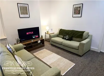 a living room with a couch and a tv at 38 Gloucester street by Prestige Properties SA in Barrow in Furness