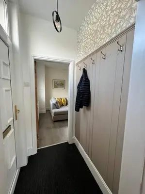 a hallway with a door and a couch in a room at Cottage in Whalley in Whalley