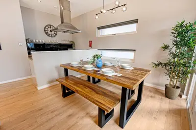 a dining room with a wooden table and a bench at Host & Stay - Ropewalks Quarters in Liverpool