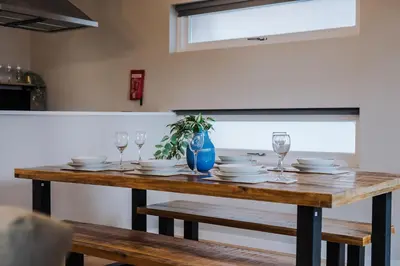 a wooden table with plates and wine glasses on it at Host & Stay - Ropewalks Quarters in Liverpool