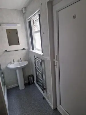 a bathroom with a sink and a window and a mirror at Vance House in Blackpool
