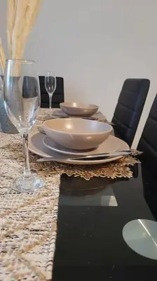 a table with two glasses and a plate of food at 4 Double Bedroom House in Accrington sleeps 6 in Accrington