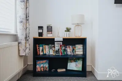 a book shelf filled with books in a room at 2 Bed Laburnum House - Free Parking & Private Yard in Blackpool