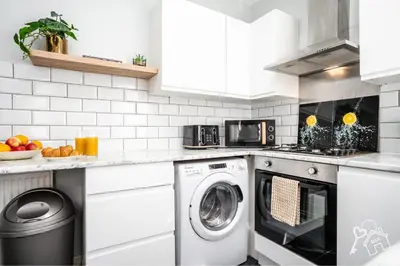 a white kitchen with a washer and dryer at 2 Bed Laburnum House - Free Parking & Private Yard in Blackpool