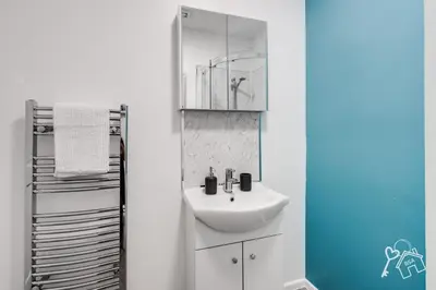 a white bathroom with a sink and a mirror at 2 Bed Laburnum House - Free Parking & Private Yard in Blackpool