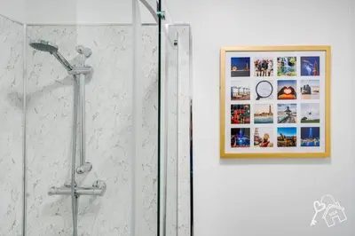 a bathroom with a shower with a picture on the wall at 2 Bed Laburnum House - Free Parking & Private Yard in Blackpool