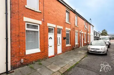 a car parked in front of a brick building at 2 Bed Laburnum House - Free Parking & Private Yard in Blackpool