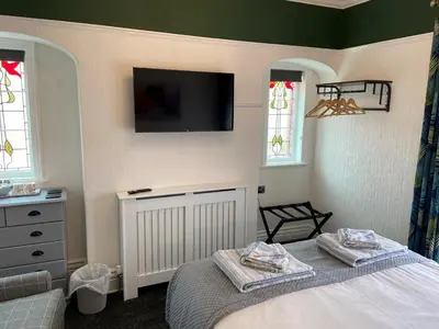 a bedroom with a bed and a tv on the wall at The Beechcliffe Hotel - Over 35's Only in Blackpool