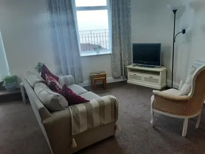 a living room with a couch and a tv at Morecambe Central balcony with sea view in Morecambe