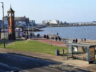 a clock tower next to a body of water at Morecambe Central balcony with sea view in Morecambe