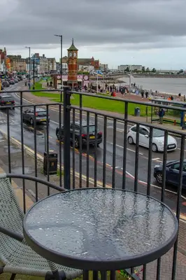 a table on a balcony with a view of a street at Morecambe Central balcony with sea view in Morecambe