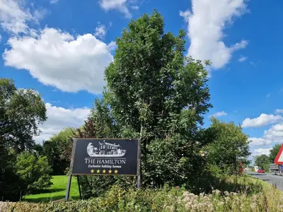 a sign for the library next to a tree at The Studio in Preston