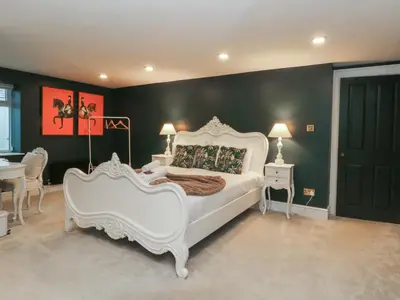 a bedroom with a white bed and a green wall at Alexander in Preston