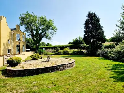 a garden with a bench in front of a house at Alexander in Preston