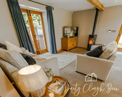 a living room with a couch and a table at Dusty Clough Barn in Preston