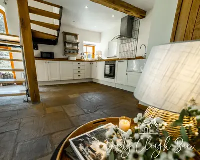 a kitchen with white cabinets and a table at Dusty Clough Barn in Preston