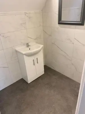 a white bathroom with a sink and a mirror at The Glenbuck Hotel Anfield in Liverpool