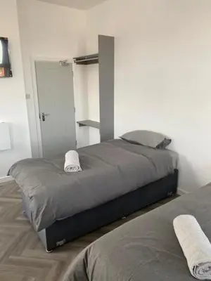 a bedroom with a large bed with a mirror at The Glenbuck Hotel Anfield in Liverpool