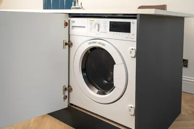 a washing machine under a counter in a kitchen at Bifolds, enclosed garden. Southport character home in Southport