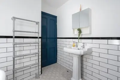 a bathroom with a sink and a blue door at Bifolds, enclosed garden. Southport character home in Southport